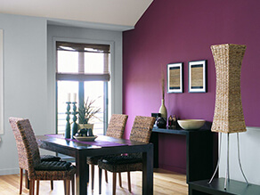 Pink feature wall with contrasting blue grey wall dark brown table and desk with cane chair
